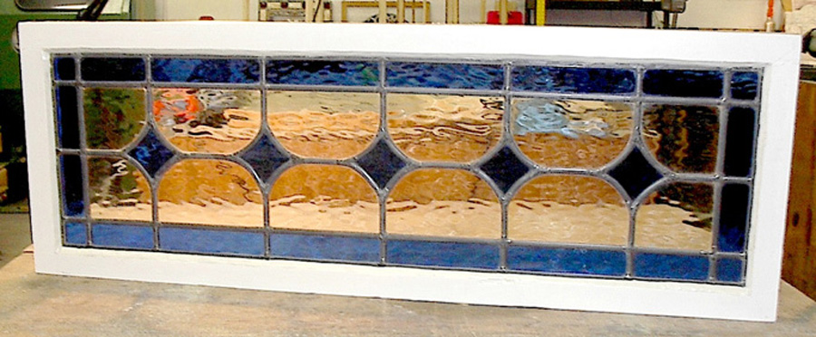 A combination of oranges and blues characterize this stained glass paneled transom